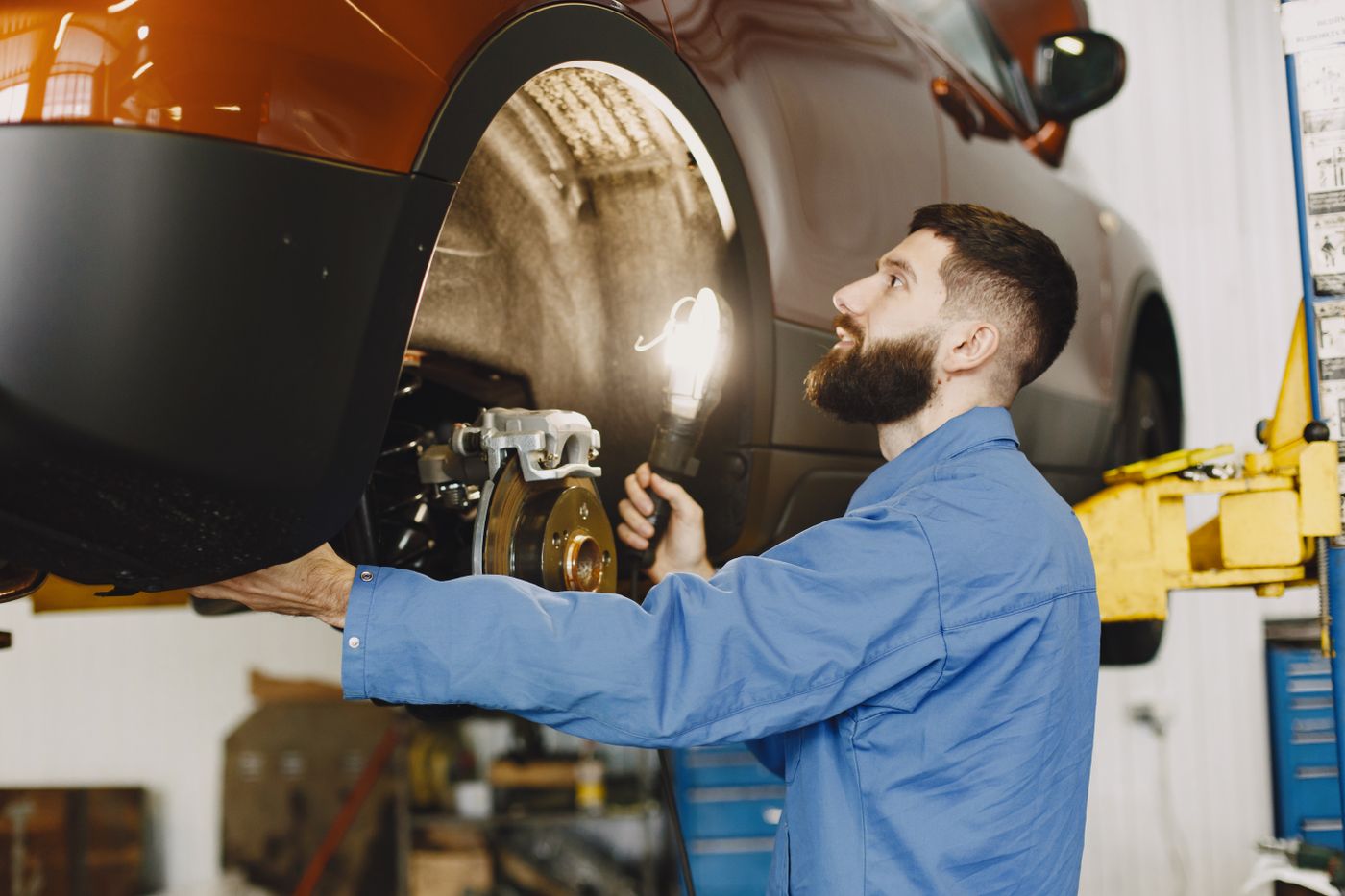 Mechaniker prüft ein Fahrzeug in der Kfz-Werkstatt